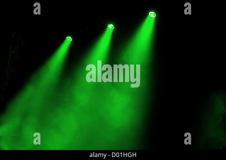 Alberi colorati di illuminazione colorata brillare attraverso fumo atmosferico in modo drammatico alla luce un palco vuoto Foto Stock