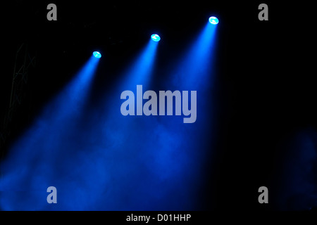 Alberi colorati di illuminazione colorata brillare attraverso fumo atmosferico in modo drammatico alla luce un palco vuoto Foto Stock