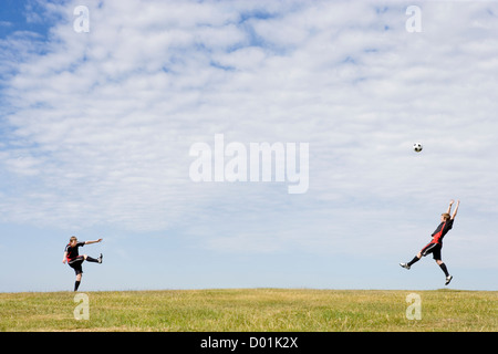 Due giovani uomini a giocare a calcio in campagna Foto Stock