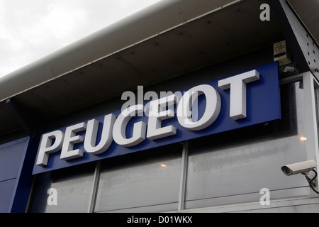 Un grande logo Peugeot sul lato di una concessionaria auto. Foto Stock