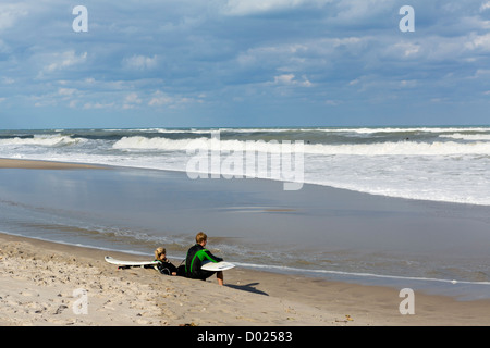 Giovani surfisti in appoggio sulla spiaggia di Giove, Palm Beach County, Treasure Coast, Florida, Stati Uniti d'America Foto Stock