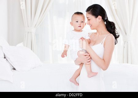 Dolce madre holding baby in armi Foto Stock