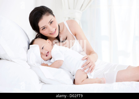 Dolce madre e bambino bello a letto Foto Stock