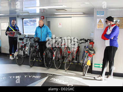 I ciclisti utilizzando gli scudi traghetto per attraversare il fiume Tyne North East England Regno Unito Foto Stock