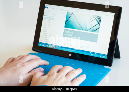 Uomo che utilizza word processor app per scrivere una relazione con la tastiera su Microsoft Surface rt computer tablet Foto Stock