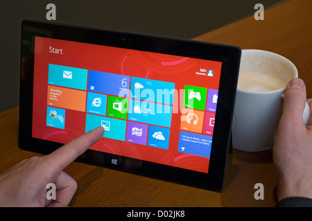 Uomo che utilizza Microsoft Surface rt computer tablet in cafe Foto Stock