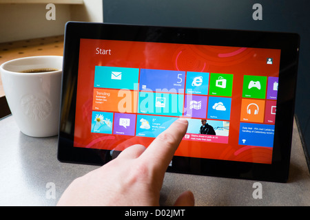 Uomo che utilizza Microsoft Surface rt computer tablet in cafe Foto Stock