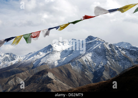 Preghiera buddista bandiere su un passa alto nella regione dolpo del Nepal con la Snow capped alta Himalaya in background Foto Stock