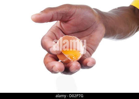 Mano azienda tuorlo d'uovo crudo in un guscio d'uovo Foto Stock