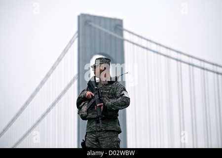 Armato di un soldato americano sta di guardia all'ombra del Verrazano-Narrows collegamento ponte di Brooklyn a Staten Island Maggio 18, 2012 a Fort Hamilton in New York City. Foto Stock