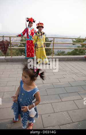 I turisti cinesi che posano per una foto indossando abiti tradizionali su una passeggiata al di sopra della Città Proibita di Pechino, Cina. Foto Stock