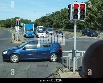 Suburbana di flusso di traffico, fermo ad un semaforo di intersezione stradale nella città di Galway in Irlanda dell'Ovest. Foto Stock