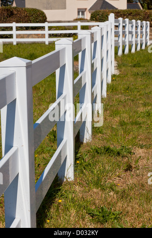 Paese nuovo bianco recinzione in plastica dopo la falciatura. Giornata di sole Foto Stock