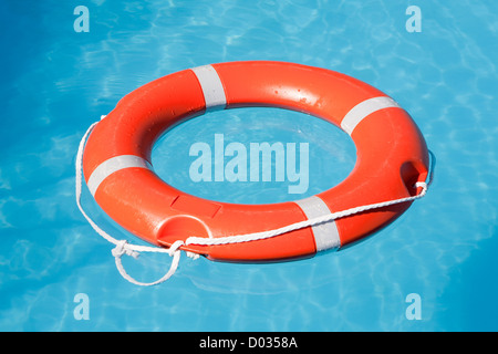 Red lifesaving galleggiare su acqua blu Foto Stock