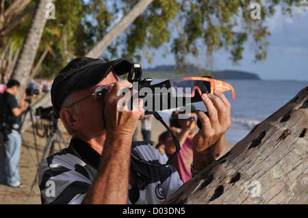 Uno spettatore guarda l'eclisse solare totale come tagliare tutta la punta settentrionale dell Australia Novembre 13, 2012 in Cairns, Australia. Un'Eclisse Solare si verifica quando la Luna incrocia tra il sole e la terra bloccando il sole completamente o parzialmente. Questo Celesti evento può verificarsi solo nel giorno di una luna nuova quando il sole e la luna si trova in congiunzione ad ogni altro quando visti dalla terra. Foto Stock