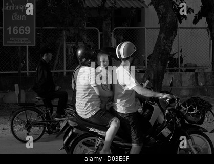 Bambino sul retro della moto in Thailandia Foto Stock