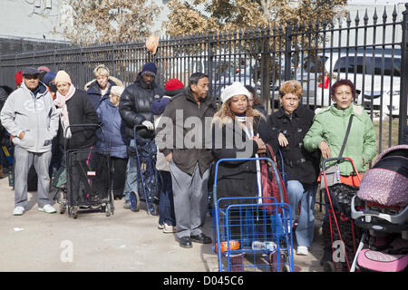 New York, Stati Uniti d'America. Il 14 novembre 2012. Quasi tre settimane dopo l uragano Sandy la pulitura e il disagio si accende. Coney Island quartiere, Brooklyn, New York. I residenti dal disco hit Coney Island quartiere di Brooklyn, NY ricevere gratuitamente il cibo e i materiali di consumo distribuiti dagli Angeli Custodi di quasi 3 settimane dopo la tempesta. Foto Stock