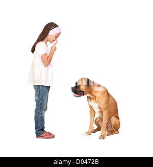 Adorabile ragazza ordinazione di silenzio il suo cane isolato su sfondo bianco Foto Stock