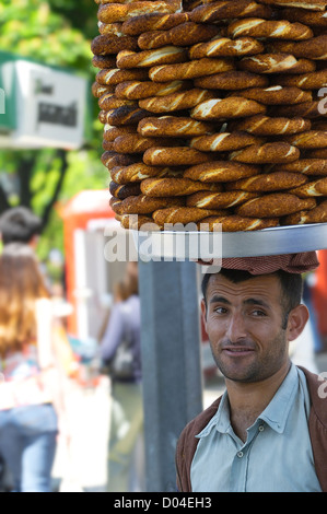 Fornitore di strada con Simit (mazzi di semi di sesamo) su vassoio portato sulla sua testa a Istanbul, Turchia Foto Stock