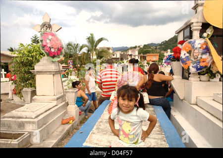 Una giovane ragazza seduta in un cimitero in Puerto Vallarta durante il giorno dei morti (El dia de los Muertos) - 2 Novembre 2012 Foto Stock