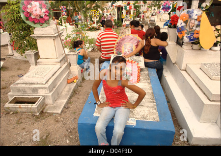 Una giovane ragazza seduta in un cimitero in Puerto Vallarta durante il giorno dei morti (El dia de los Muertos) - 2 Novembre 2012 Foto Stock