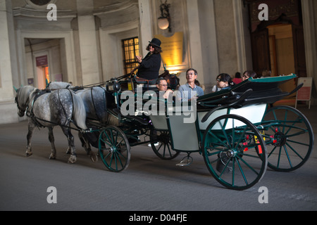 Cavalli tradizionale e carrello (chiamato anche Fiaker) guidando attraverso il famoso Hofburg il 3 ottobre 2012 a Vienna, Austria. Foto Stock