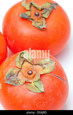 Persimmons arancione isolati su sfondo bianco Foto Stock