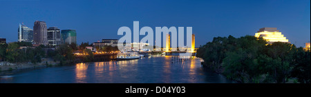 Panorama della città di Sacramento skyline al tramonto, compreso il centro di edifici, il Delta King in barca sul fiume e il Tower Bridge. Foto Stock