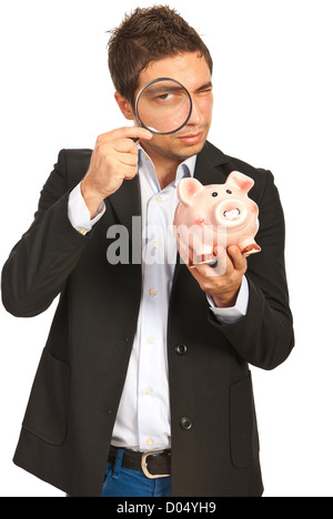 Uomo che guarda attraverso la lente di ingrandimento attraverso piggybank nel suo canto isolato su sfondo bianco Foto Stock