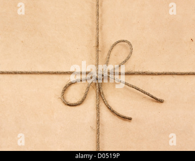 Stringa legato in un arco sulla carta riciclata marrone Foto Stock