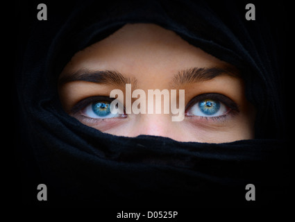 Bella donna blu occhi dietro foulard nero cercando Foto Stock