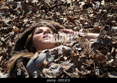 Donna sepolti nelle foglie di quercia Foto Stock