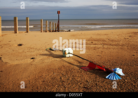 Una vista della vecchia struttura di frangionde posti e una lavata fino la pesca boa segnaletica sulla spiaggia Horsey, Norfolk, Inghilterra, Regno Unito. Foto Stock