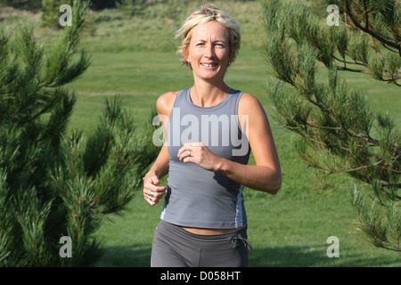 Donna bionda all'esterno. Jogging in campagna. Foto Stock