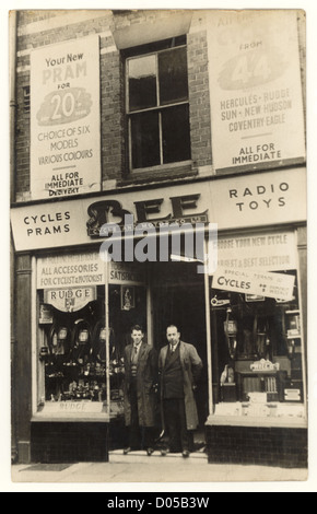 Negozianti proprietario o personale /assistente/assistenti al di fuori del ciclo di Bee e Motor Co., Liverpool, biciclette esposti nel negozio fronti finestra, Regno Unito all'inizio degli anni trenta Foto Stock