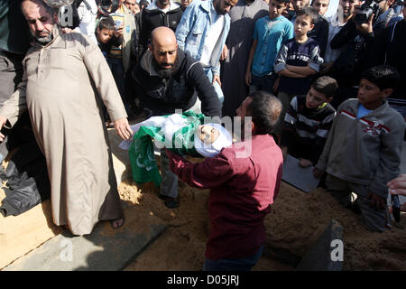 Nov. 18, 2012 - Gaza City, nella Striscia di Gaza, Territori palestinesi - un uomo palestinese porta il corpo di uno dei bambini alla tomba durante il loro funerale nel nord della Striscia di Gaza il 18 novembre 2012. Due bambini Jumana Abu Seifan, 18 mesi di età, e suo fratello Tamer, tre anni e mezzo di età, sono stati uccisi in un attacco aereo israeliano di domenica, ospedale hanno detto i funzionari. Israele ha bombardato obiettivi militante nella Striscia di Gaza per un quinto dritto nella giornata di domenica, il lancio di antenna e attacchi navali come suo militare preparato per una possibile invasione di terra, sebbene Egitto visto ''Some indicazioni'' di una tregua in avanti (credito mi Foto Stock