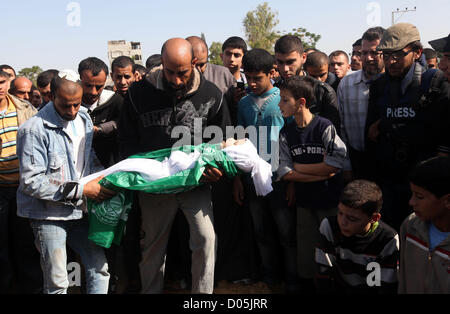 Nov. 18, 2012 - Gaza City, nella Striscia di Gaza, Territori palestinesi - un uomo palestinese porta il corpo di uno dei bambini alla tomba durante il loro funerale nel nord della Striscia di Gaza il 18 novembre 2012. Due bambini Jumana Abu Seifan, 18 mesi di età, e suo fratello Tamer, tre anni e mezzo di età, sono stati uccisi in un attacco aereo israeliano di domenica, ospedale hanno detto i funzionari. Israele ha bombardato obiettivi militante nella Striscia di Gaza per un quinto dritto nella giornata di domenica, il lancio di antenna e attacchi navali come suo militare preparato per una possibile invasione di terra, sebbene Egitto visto ''Some indicazioni'' di una tregua in avanti (credito mi Foto Stock