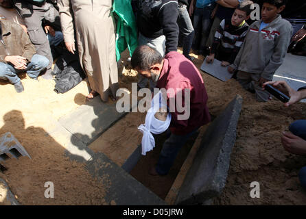 Nov. 18, 2012 - Gaza City, nella Striscia di Gaza, Territori palestinesi - un uomo palestinese porta il corpo di uno dei bambini alla tomba durante il loro funerale nel nord della Striscia di Gaza il 18 novembre 2012. Due bambini Jumana Abu Seifan, 18 mesi di età, e suo fratello Tamer, tre anni e mezzo di età, sono stati uccisi in un attacco aereo israeliano di domenica, ospedale hanno detto i funzionari. Israele ha bombardato obiettivi militante nella Striscia di Gaza per un quinto dritto nella giornata di domenica, il lancio di antenna e attacchi navali come suo militare preparato per una possibile invasione di terra, sebbene Egitto visto ''Some indicazioni'' di una tregua in avanti (credito mi Foto Stock