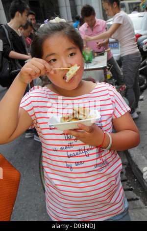 Shanghai Cina, cinese Huangpu District, Dianchi Road, ragazze asiatiche ragazze ragazza, giovane, femmina bambini gnocchi bambini, mangiare, cibo, strada, venditori ambulanti stallo Foto Stock