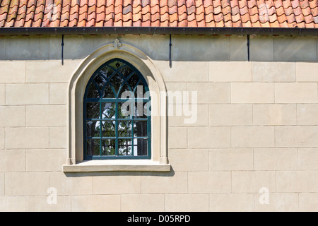 La parete della chiesa con un arco a sesto acuto finestra Foto Stock