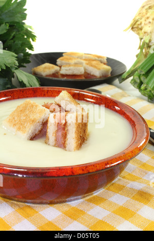 Crema cotta di zuppa di sedano con crostini di salmone su un tovagliolo a scacchi prima di sfondo luminoso Foto Stock
