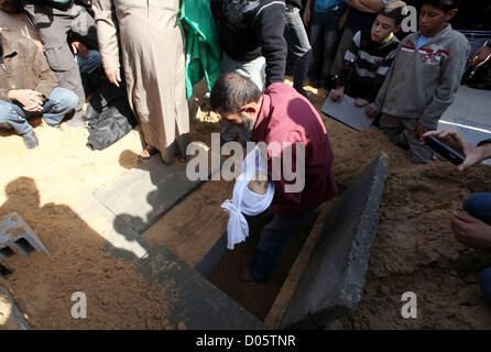 Nov. 18, 2012 - Gaza City, nella Striscia di Gaza - un uomo palestinese porta il corpo di suo figlio per la sua grave durante un funerale nel nord della Striscia di Gaza. Due bambini Jumana Abu Seifan, 18 mesi di età, e suo fratello Tamer, tre anni e mezzo di età, sono stati uccisi in un attacco aereo israeliano di domenica, ospedale hanno detto i funzionari. (Credito Immagine: © Majdi Fathi/immagini APA/ZUMAPRESS.com) Foto Stock