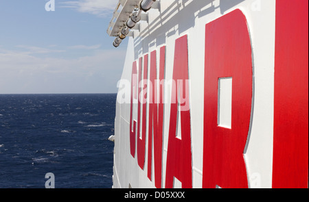 Logo Cunard sul fascio del porto della nave da crociera RMS Queen Mary 2 nella baia di Biscaglia Foto Stock