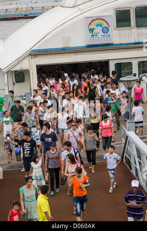 Una folla di gente che esce da un fiume Huangpu ferry Shanghai, Cina Foto Stock