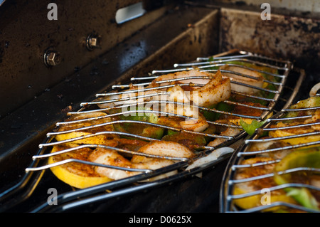 La grigliatura screziato trote (spotted seatrout) filetti in un cestello di griglia Foto Stock