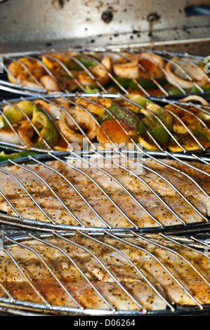 La grigliatura screziato trote (spotted seatrout) filetti in un cestello di griglia Foto Stock