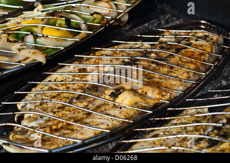 La grigliatura screziato trote (spotted seatrout) filetti in un cestello di griglia Foto Stock