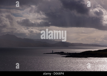 Drammatica del cielo e la luce del sole oltre il suono di Sleat con isola Ornsay faro in distanza, Scotland, Regno Unito Foto Stock