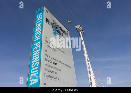 Una posizione e direzione segno sulla penisola di Greenwich, sotto il (Emirati) Thames funivia. Ci sono 34 gondole, ciascuna con una capacità massima di 10 passeggeri. La Emirates Air Line (noto anche come il Tamigi funivia) è un cavo di collegamento auto attraverso il Fiume Tamigi a Londra costruito con la sponsorizzazione da parte della compagnia aerea Emirates. Il servizio aperto il 28 giugno 2012 ed è gestito da trasporto per Londra. Il servizio, ha annunciato nel mese di luglio 2010 e un costo stimato di £ 60 milioni, comprende un 1-chilometro (0,62 mi) gondola linea che attraversa il Tamigi dalla penisola di Greenwich al Royal Docks. Foto Stock