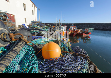 Le reti da pesca e le barche nel porto tradizionale a Dunbar, East Lothian, Scozia. Foto Stock